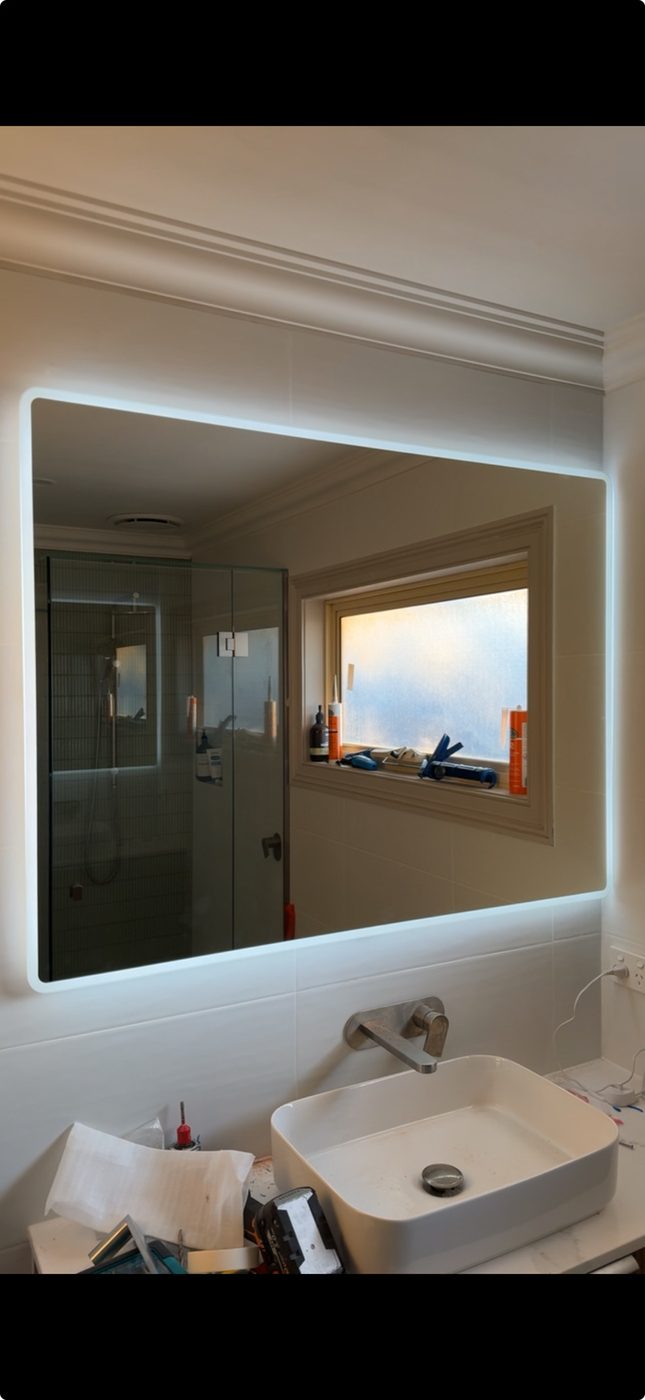 Bathroom with a large backlit LED mirror and vessel basin