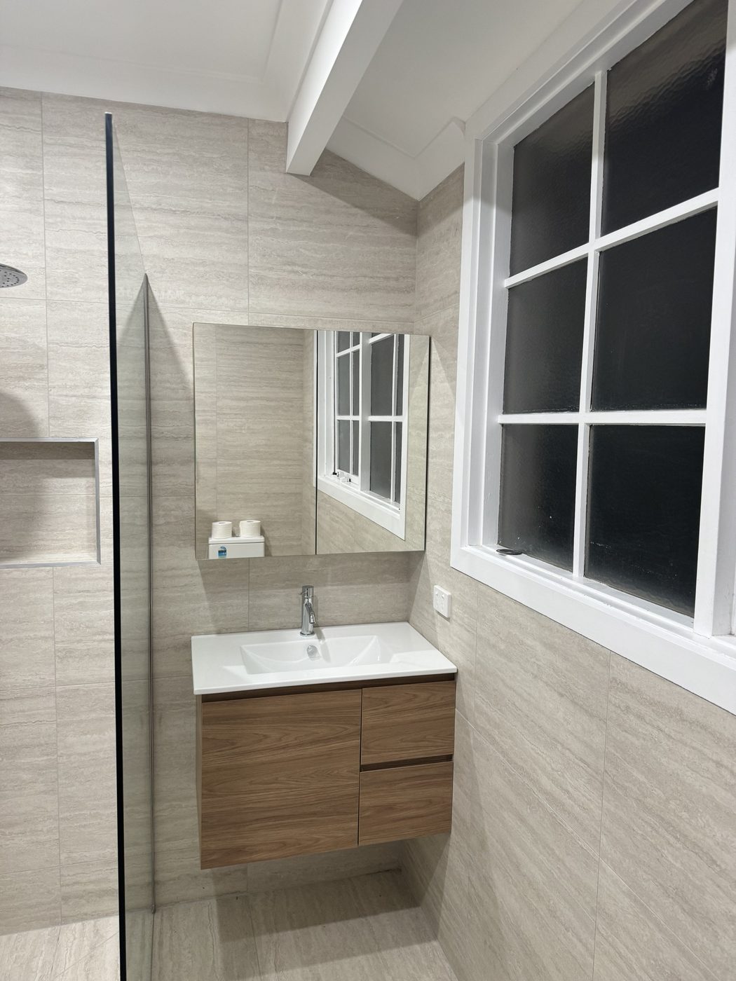 Bathroom with timber vanity, mirror and white-framed window