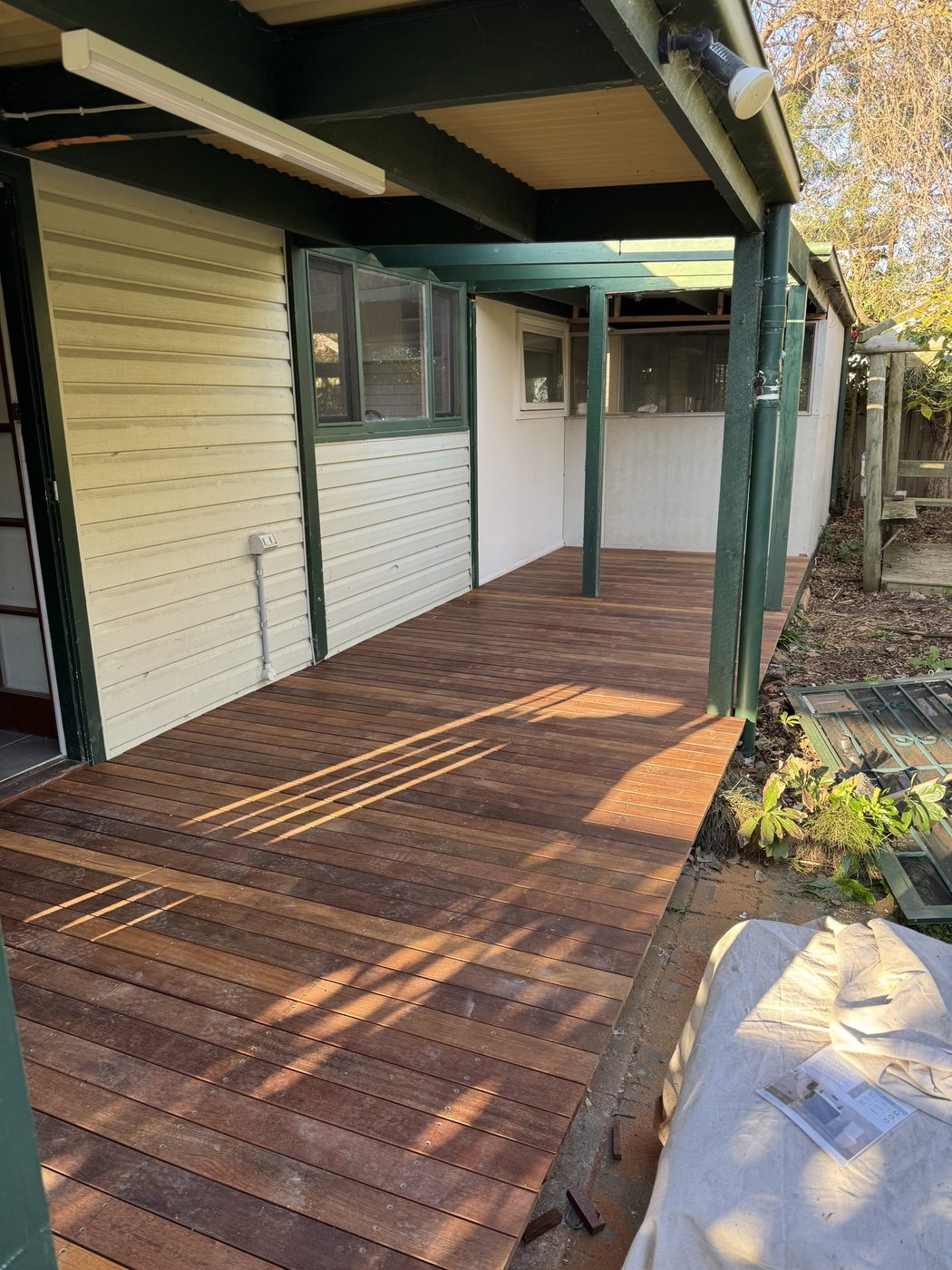 Freshly oiled hardwood deck beside a weatherboard home
