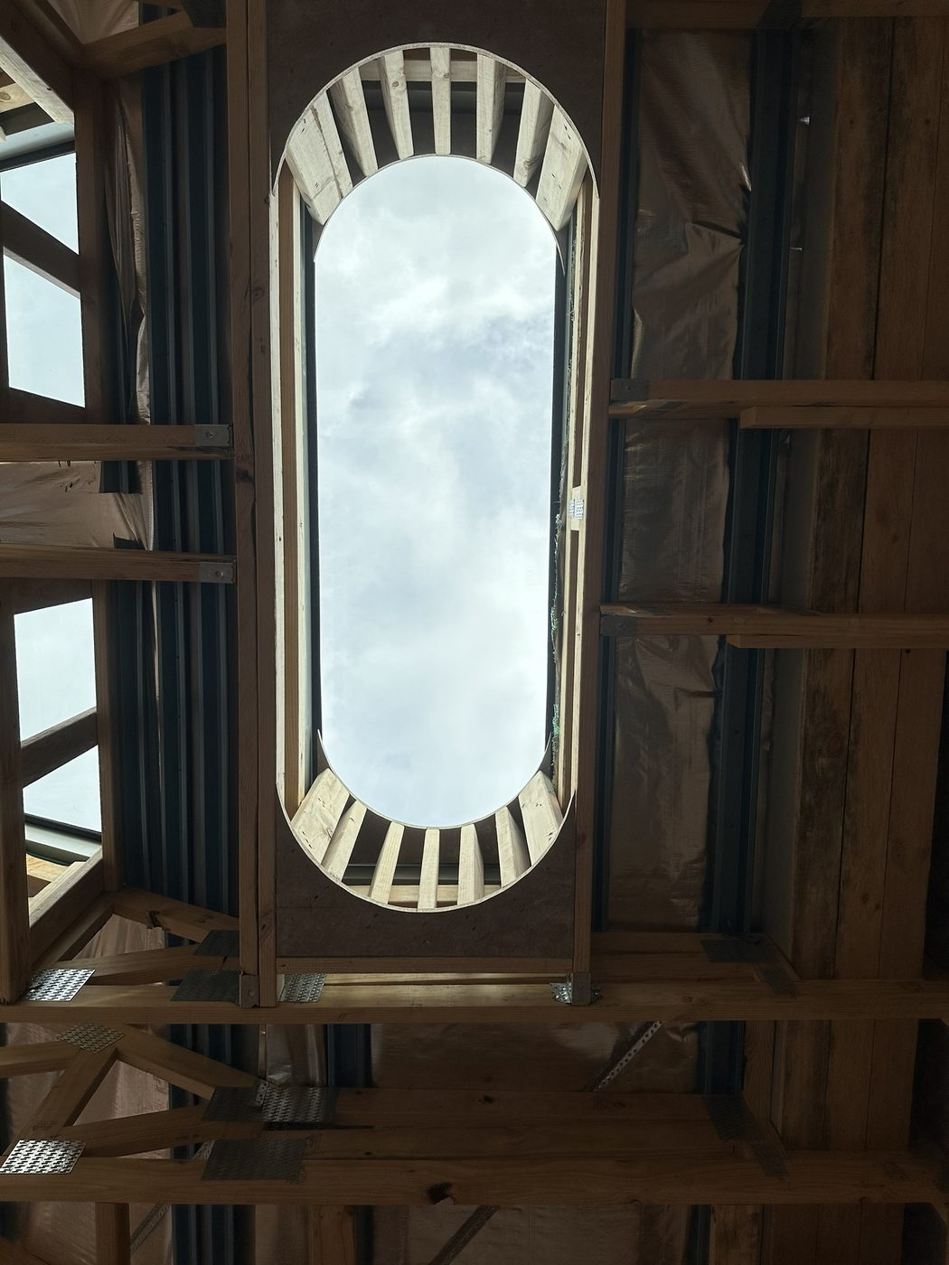 Timber roof framing with an arched window opening framed out
